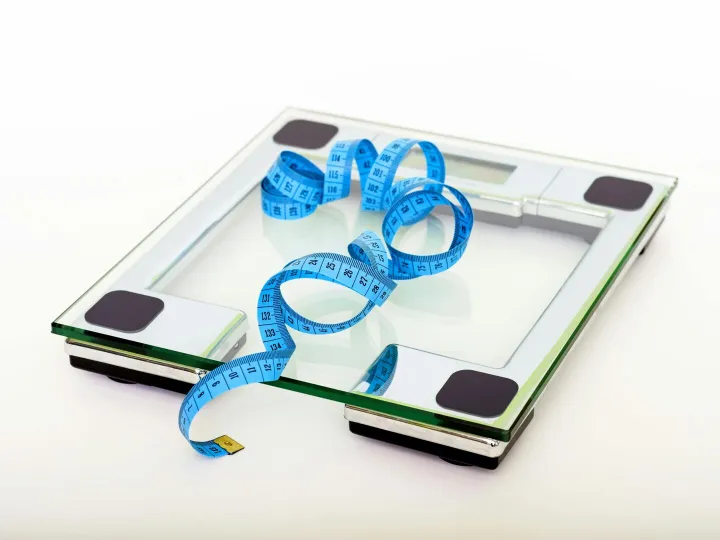 A digital glass weighing scale with a blue
