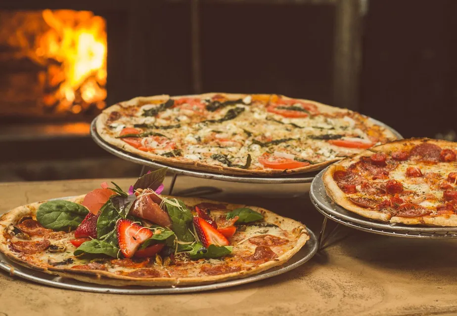 Trio of gourmet pizzas with unique toppings near