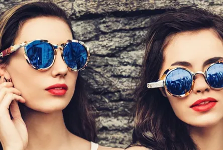 Two women wearing retro sunglasses