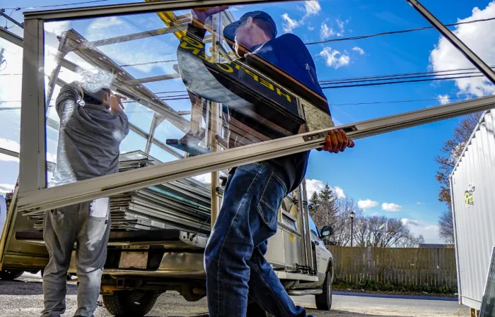 Workers unloading aluminium window