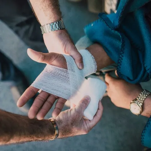 Person Applying Bandage on Another Person's Hand
