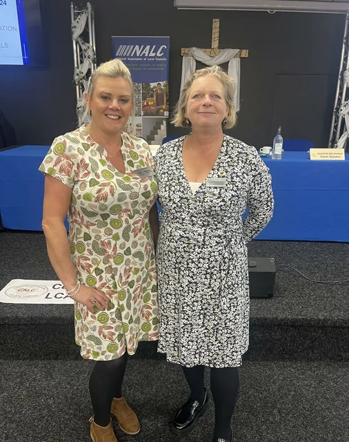 Nikki and Sharon from the ChALC team standing in front of an NALC banner