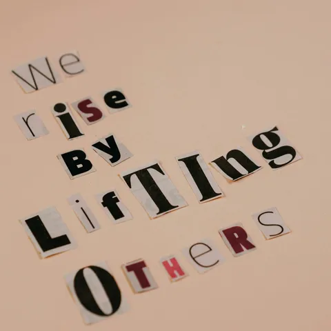 Cutout letters forming an inspirational quote on a beige background, encouraging positivity.