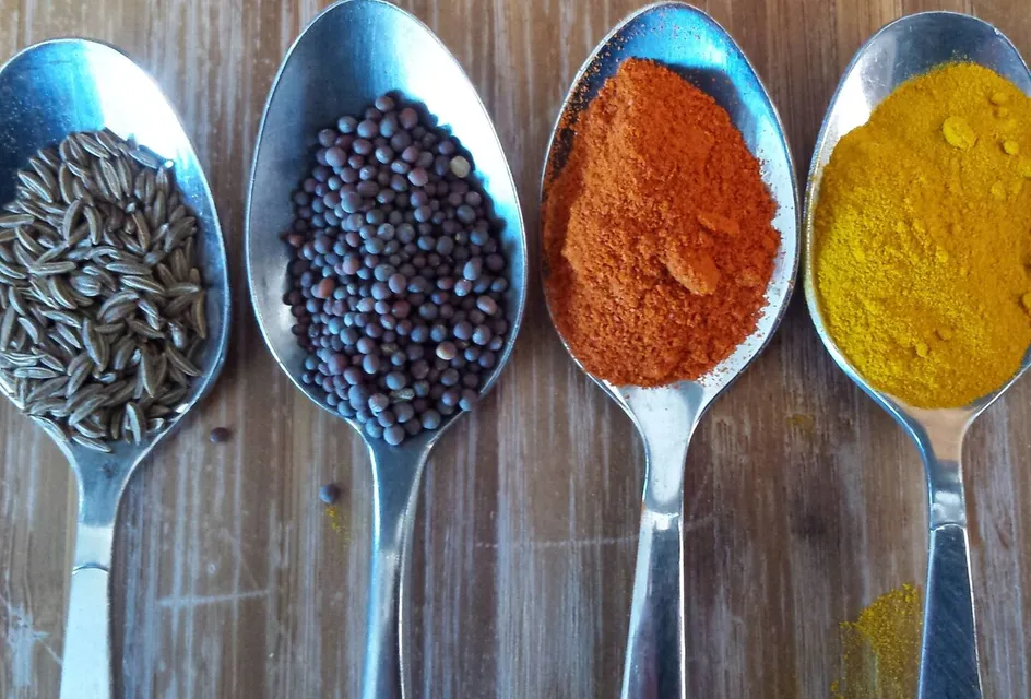 Four teaspoons of coloured condiments