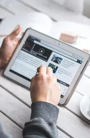A man uses a tablet to browse news while enjoying