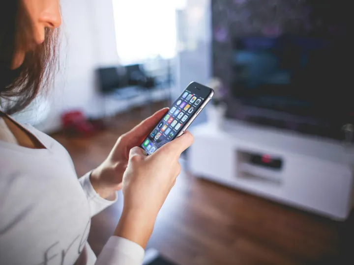 Woman browsing smartphone indoors, highlighting