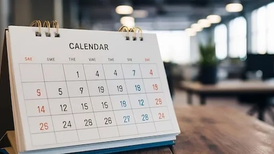 White paper desk calendar on wood table top with