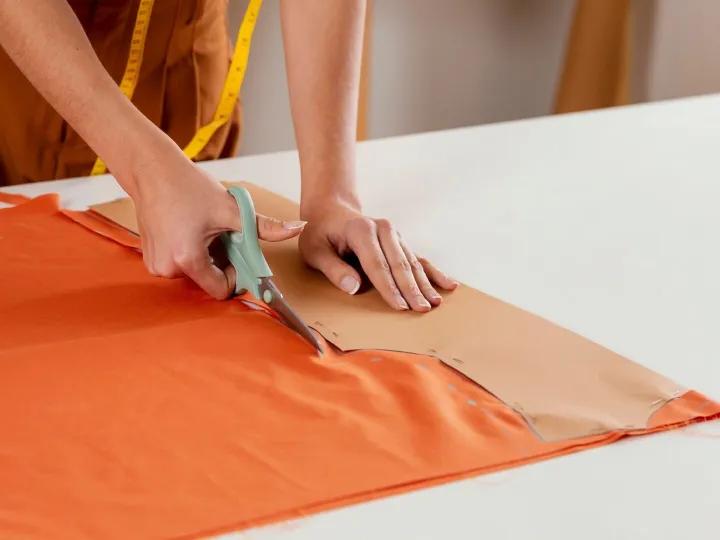 Close-up hands cutting fabric