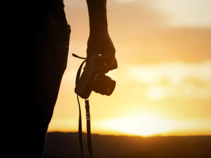 Backpacker relax on the Mountain with camera adn sunset