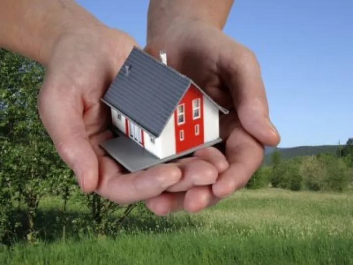 Hands holding a toy house