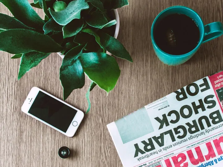 Flat lay arrangement of a coffee mug, newspaper