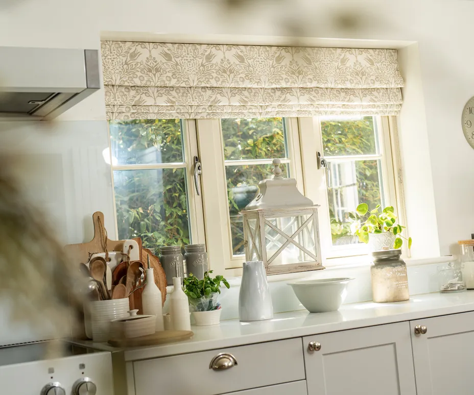 Patterned roman blinds in cream and white kitchen