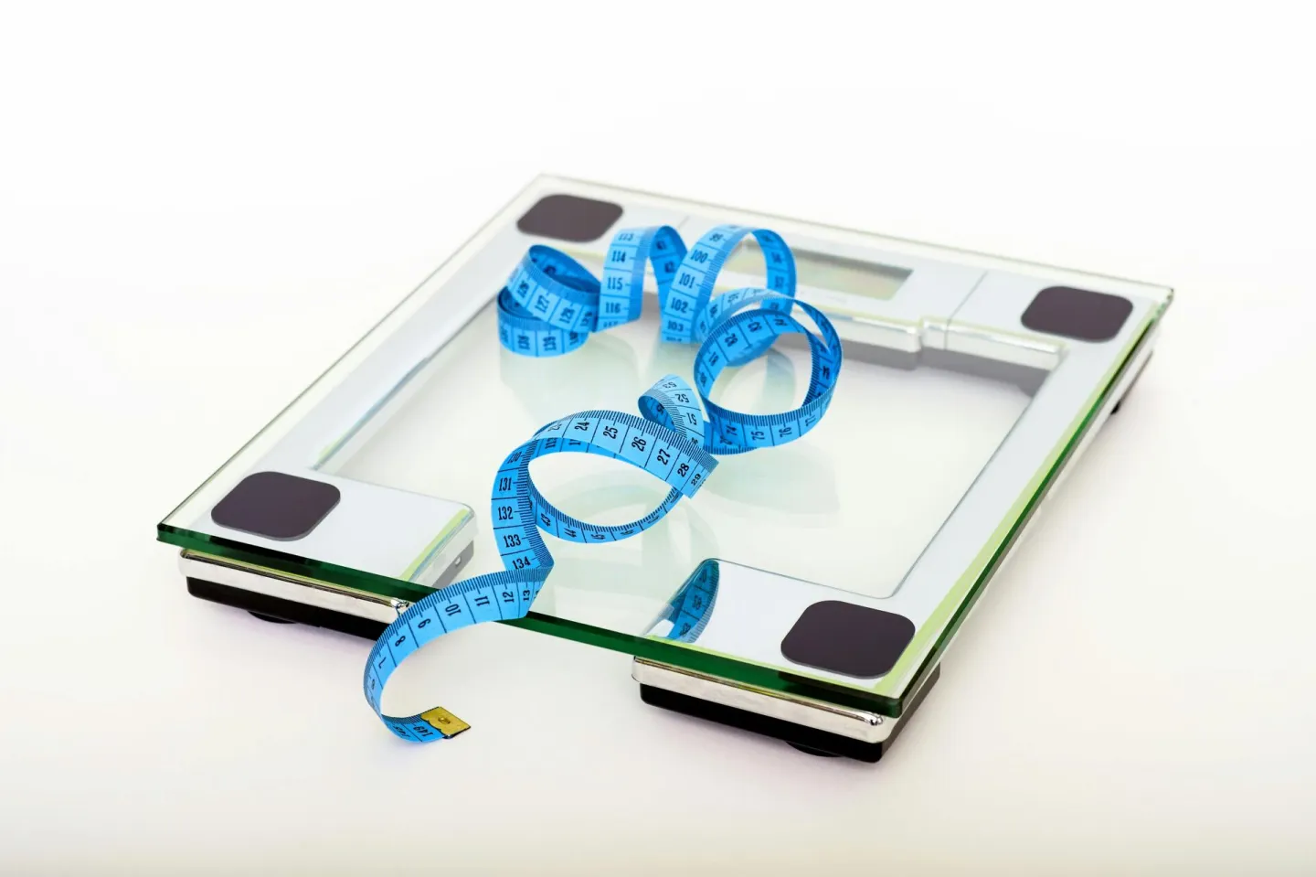 A digital glass weighing scale with a blue