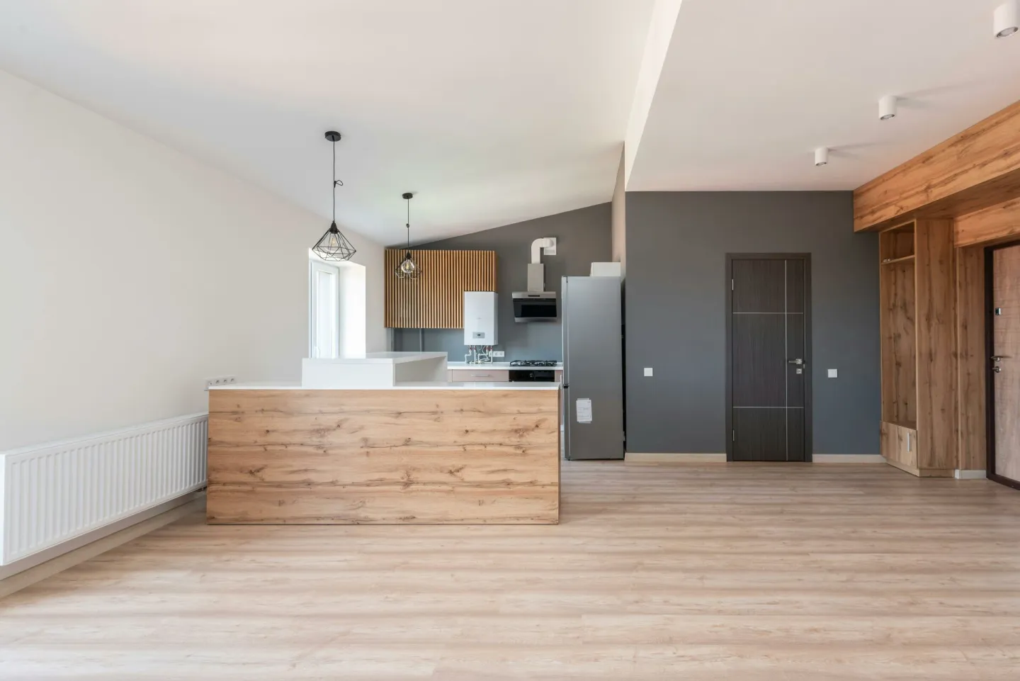 Explore a stylish and minimalistic open-plan kitchen with wood accents and modern design.