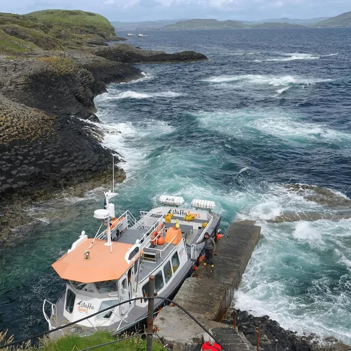 Tourist boat docked at Fingal's Cave, Isle of 