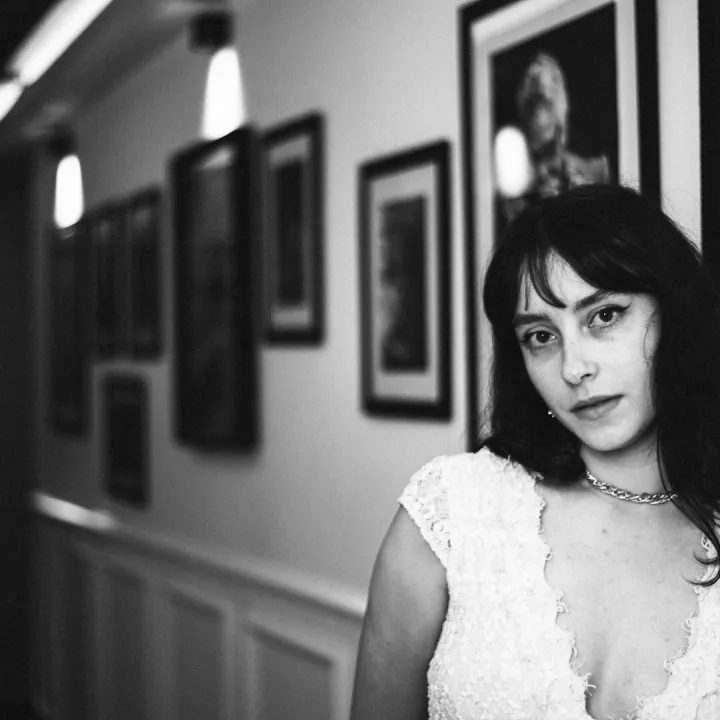 Elegant black and white portrait of a woman in a vintage-inspired hallway setting.