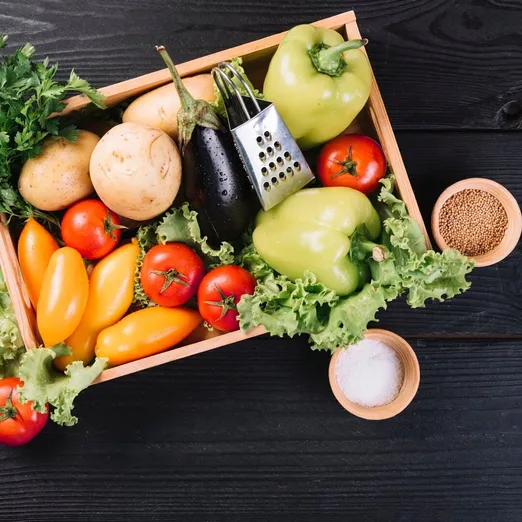 Fresh vegetables in container and spices on black