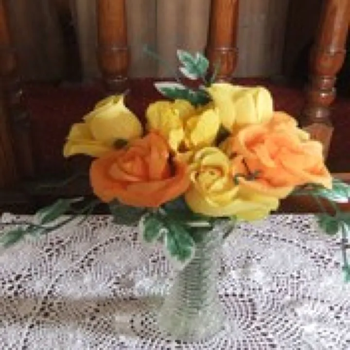 Vase of orange and yellow flowers on display at Mawla