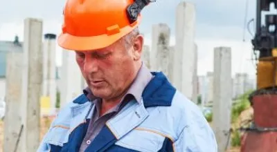 Construction workers  in front of pile driver machine