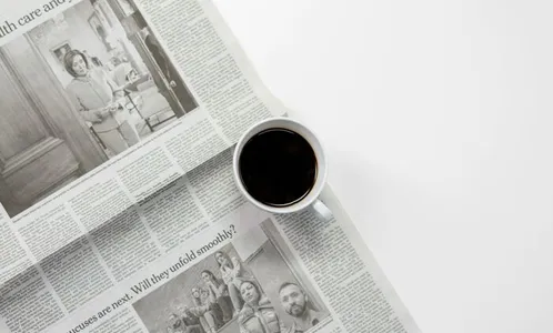 White Ceramic Mug On Top of a Newspaper