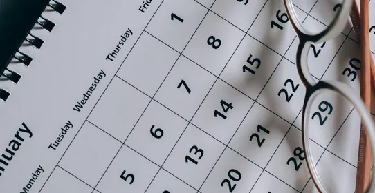 A close-up of a January calendar with eyeglasses