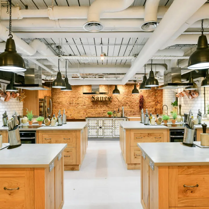 A cookery school kitchen with workstations laid out for a class