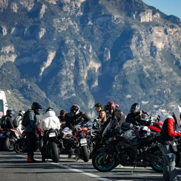 Motorcyclists gathered on a mountain road with stu