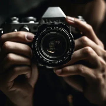 A person's hands holding a camera and taking a photo rep
