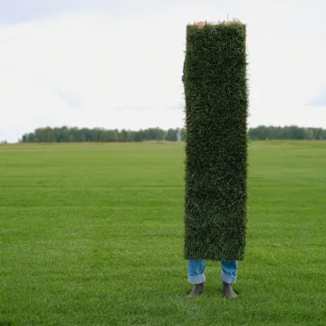 Unrecognizable farmer with grass lawn