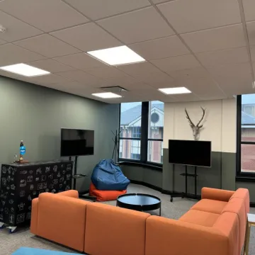 Office casual meeting area with orange sofas