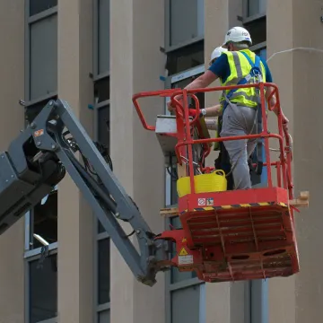 Worker painting on a cherry picker