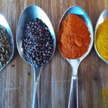 Four teaspoons of coloured condiments