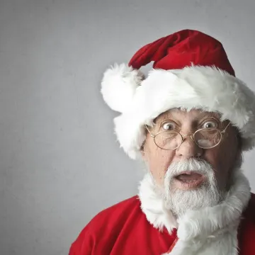 A surprised Santa Claus in traditional red outfit