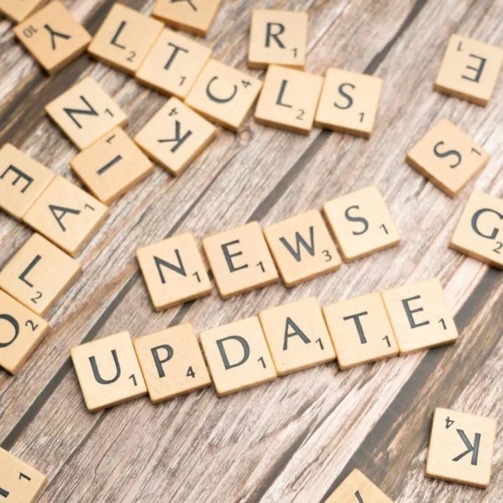 Scrabble tiles spelling 'News Update' on a wooden
