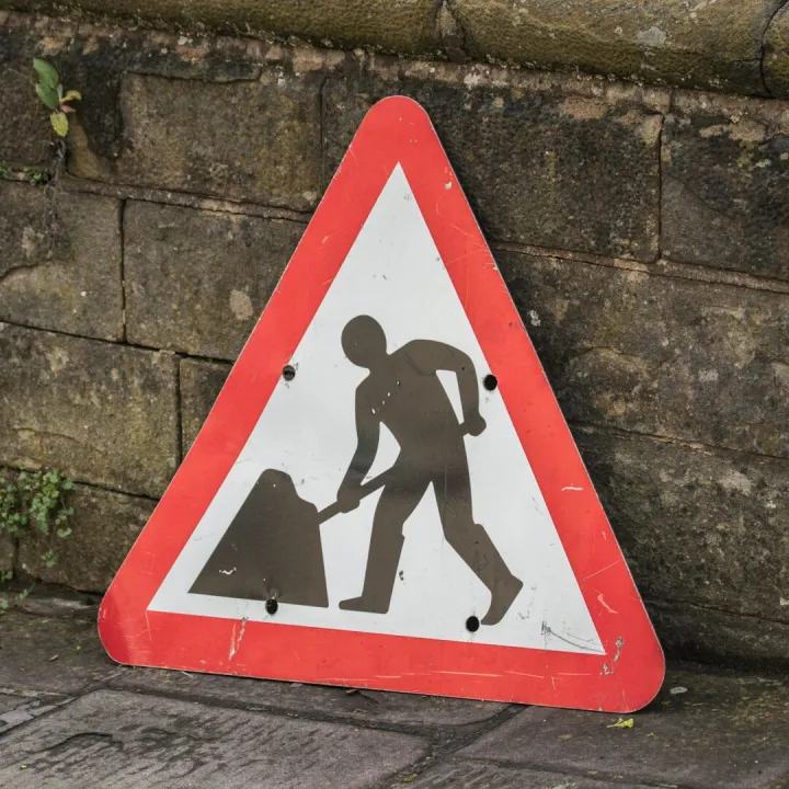 Triangular road work sign placed on a city