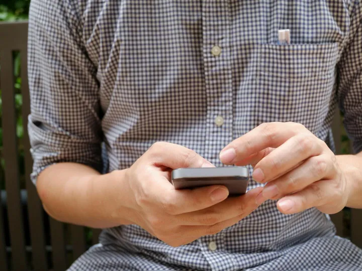 Close-up of a man using a smartphone, focusing on