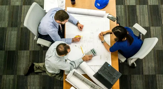 Top view of a team working on construction plans