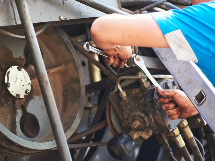 Combine machine service, mechanic repairing motor 