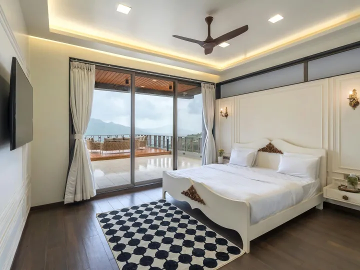 A spacious modern bedroom with a double bed and soft natural light