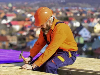 Roofer worker in special protective work wear new roof under