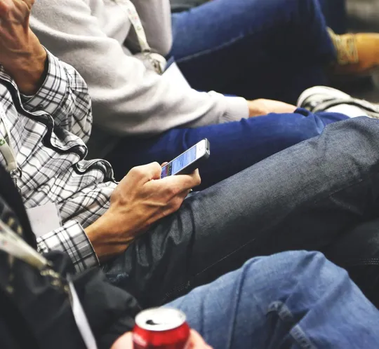 People sitting at a conference casually checking