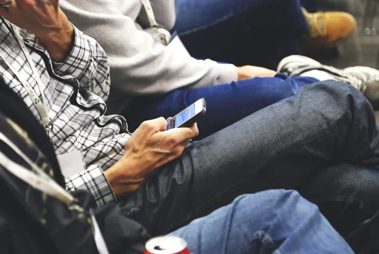 People sitting at a conference casually checking