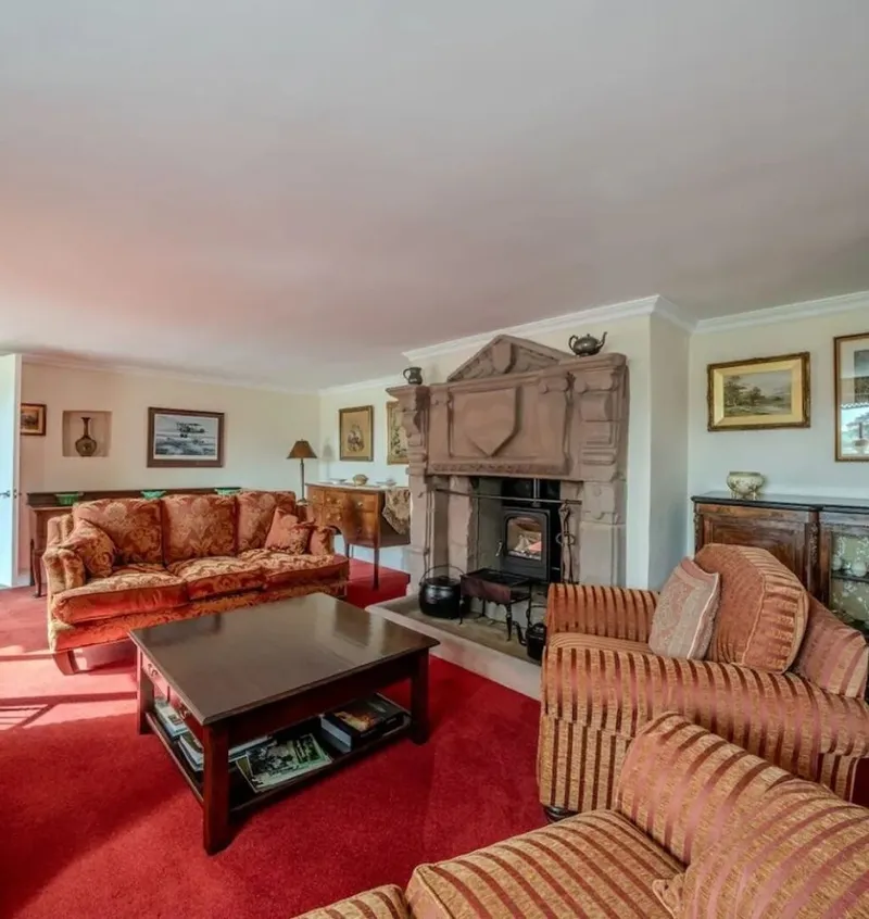 The lounge with sofas around the 18th century fireplace and log burner