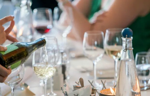Person Pouring Wine on Clear Wine Glass
