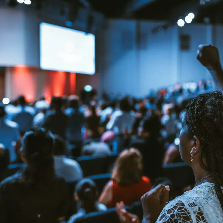Vibrant crowd at a conference with a focus on an attentive participant.
