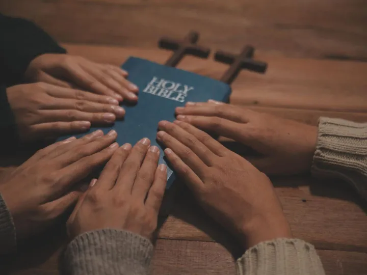 Christian group are praying to god with the bible and sharin