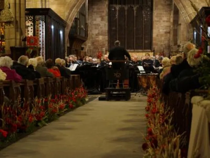 John Naylor conducting the orchestra at The Armed Man Concert