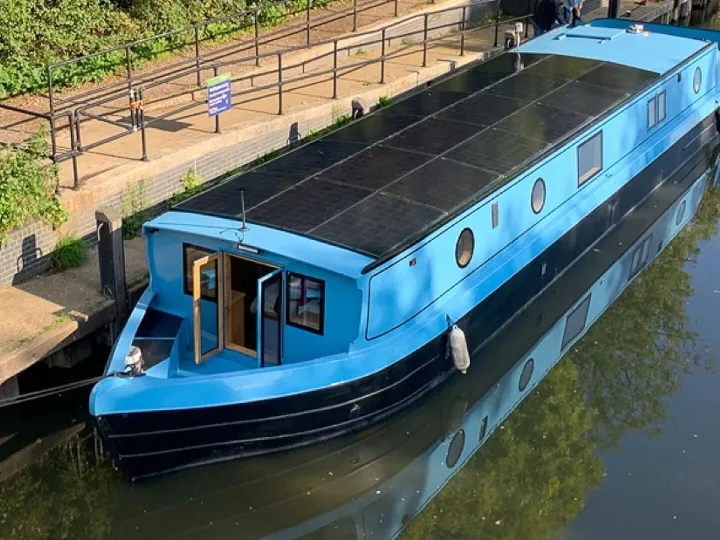 Solar roof panels on blue widebeam river boat
