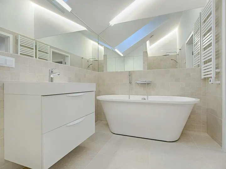 Elegant minimalist bathroom featuring a white bathtub and sleek fixtures.