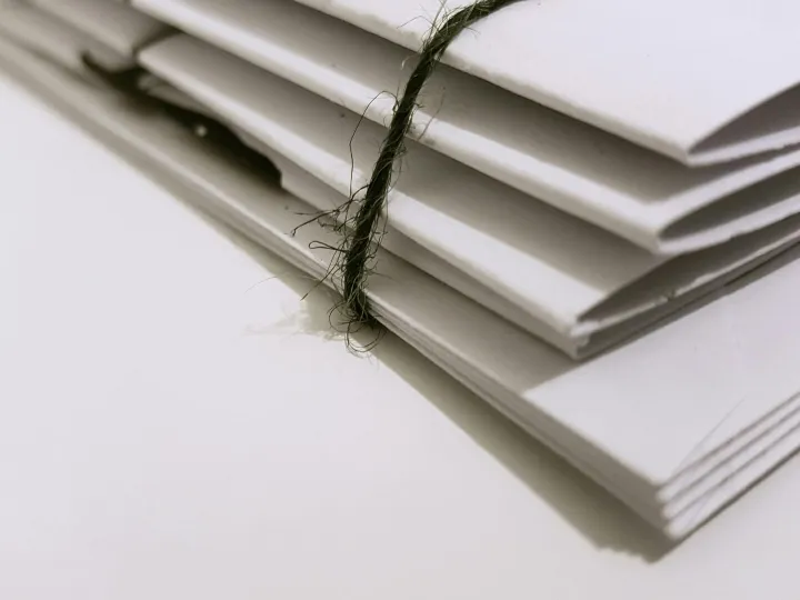 Pile of white envelopes tied with a green string